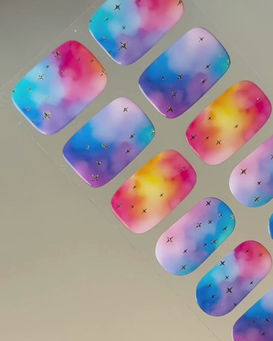 Anwendung und Detailansicht der Cotton Candy Cosmos Nailpolish Wraps mit leuchtenden Galaxie-Farben und goldenen Metallic-Sternen.