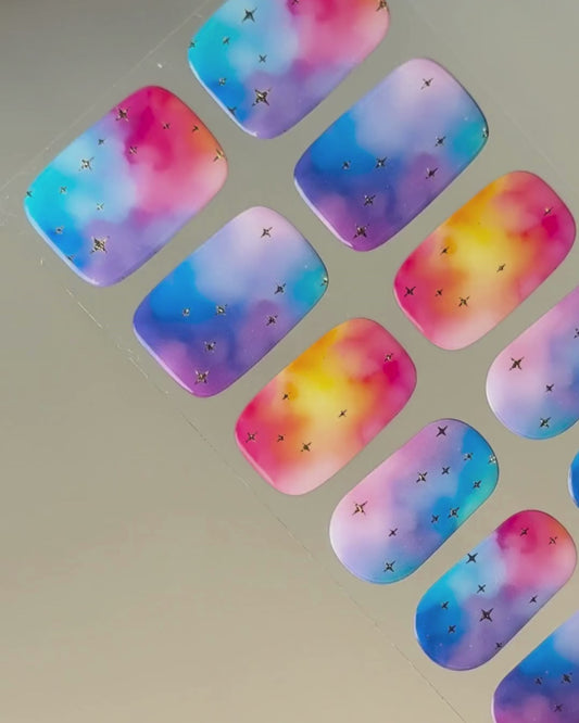 Anwendung und Detailansicht der Cotton Candy Cosmos Nailpolish Wraps mit leuchtenden Galaxie-Farben und goldenen Metallic-Sternen.