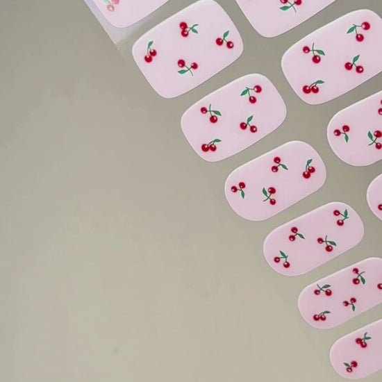 Video zur Anwendung und Ergebnis der Cherry Pop UV Gel Wraps mit milky Base und Kirsch-Design. Schritt für Schritt Aufkleben und Aushärten für eine langanhaltende Maniküre mit uv nailwraps von Die Nageltante.
