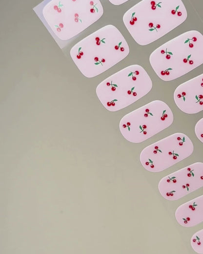 Video zur Anwendung und Ergebnis der Cherry Pop UV Gel Wraps mit milky Base und Kirsch-Design. Schritt für Schritt Aufkleben und Aushärten für eine langanhaltende Maniküre mit uv nailwraps von Die Nageltante.