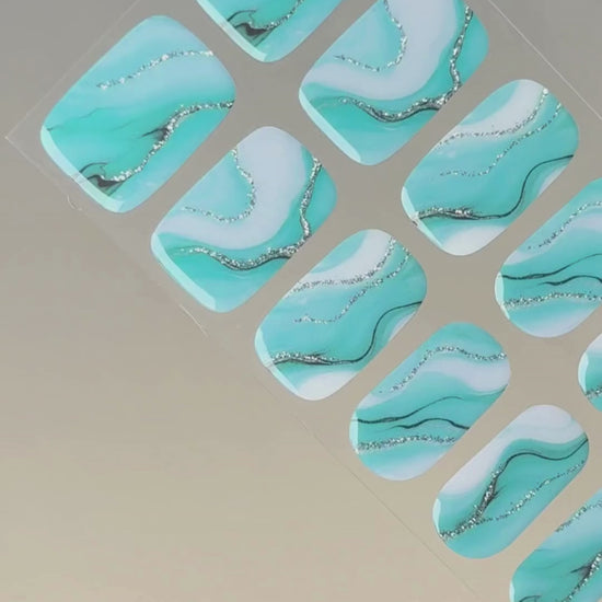 Anwendung und Detailansicht der Tide & Seek UV Gel Wraps mit türkis-blauem Ozean-Marmoreffekt.