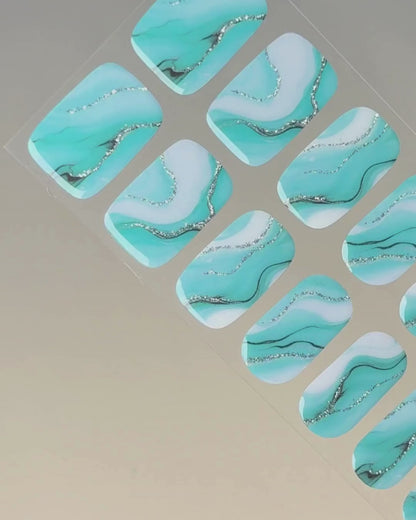 Anwendung und Detailansicht der Tide & Seek UV Gel Wraps mit türkis-blauem Ozean-Marmoreffekt.