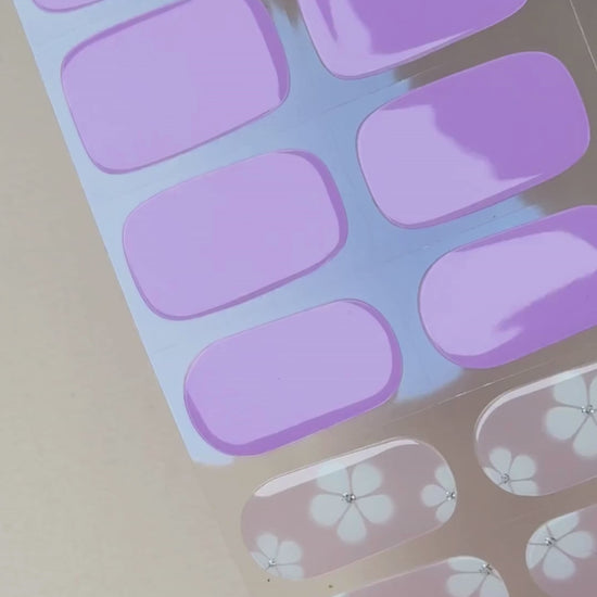 Video zur Anwendung und Ergebnis der Bloom, Please UV Gel Wraps mit lilafarbenem Design und Blüten-Details. Schritt für Schritt Aufkleben und Aushärten für eine langanhaltende Maniküre mit uv nailwraps von Die Nageltante.