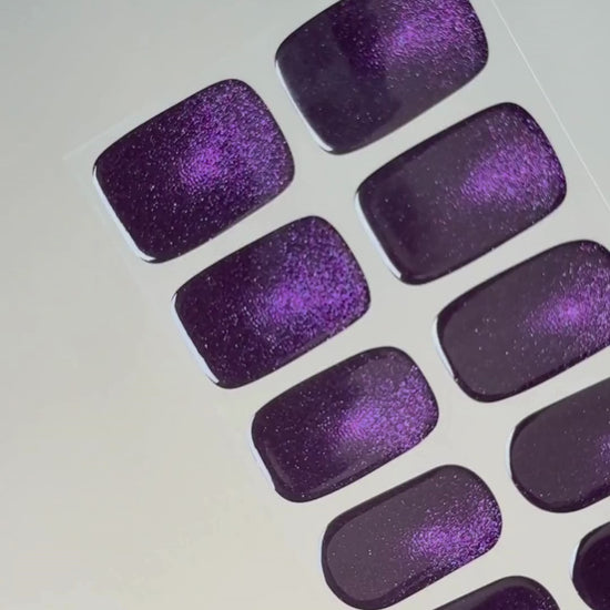 Anwendung und Detailansicht der Cosmic Dust Cat Eye UV Gel Wraps mit intensivem Violett und faszinierendem magnetischem Schimmer.