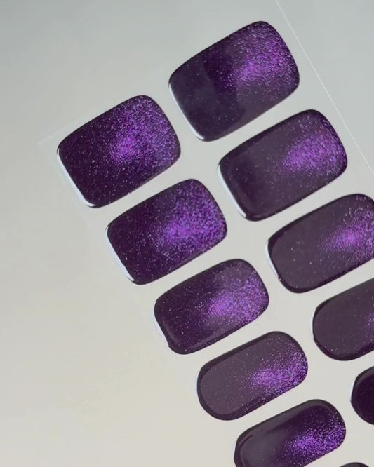 Anwendung und Detailansicht der Cosmic Dust Cat Eye UV Gel Wraps mit intensivem Violett und faszinierendem magnetischem Schimmer.