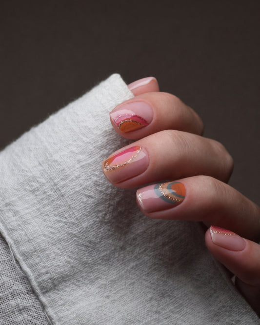 Sonnenfänger UV Gel Wraps mit bunten Regenbogen-Motiven in Koralle, Pink und Orange auf den Fingernägeln