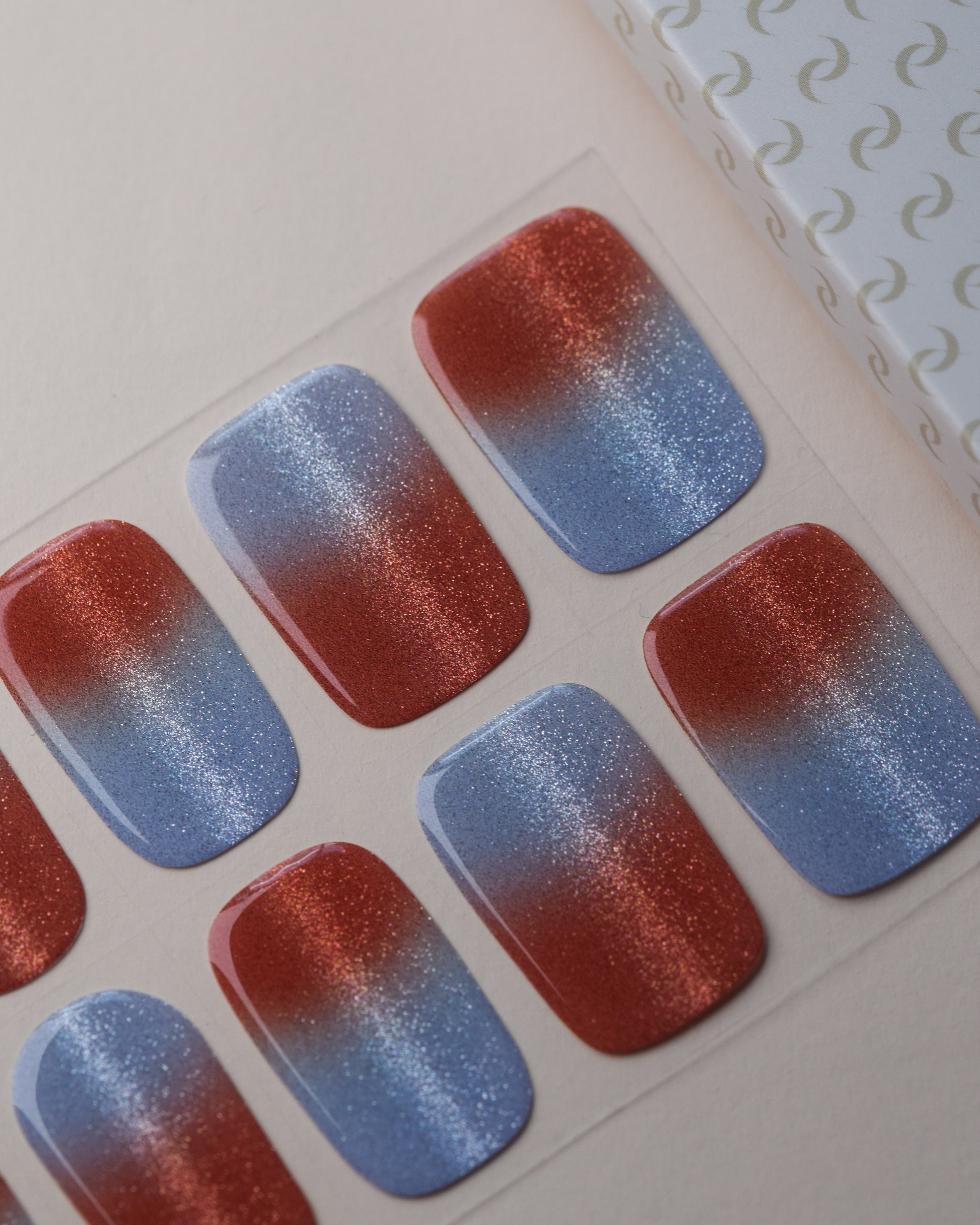 Summer Fizz Cat Eye UV Gel Wraps auf dem Designbogen mit Korallrot, Blau und schimmerndem Cat-Eye-Effekt.