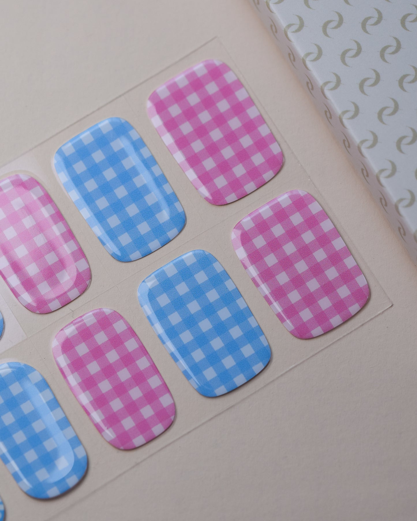 Tausendschön Nailpolish Wraps auf dem Designbogen mit rosa und blauen Vichy-Karos sowie Blumenmotiven.