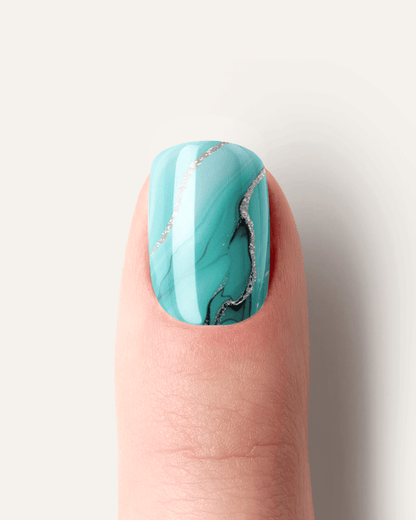 Detailaufnahme der Tide & Seek UV Gel Wraps mit fließendem Ozean-Marmoreffekt in Türkis und Blau.