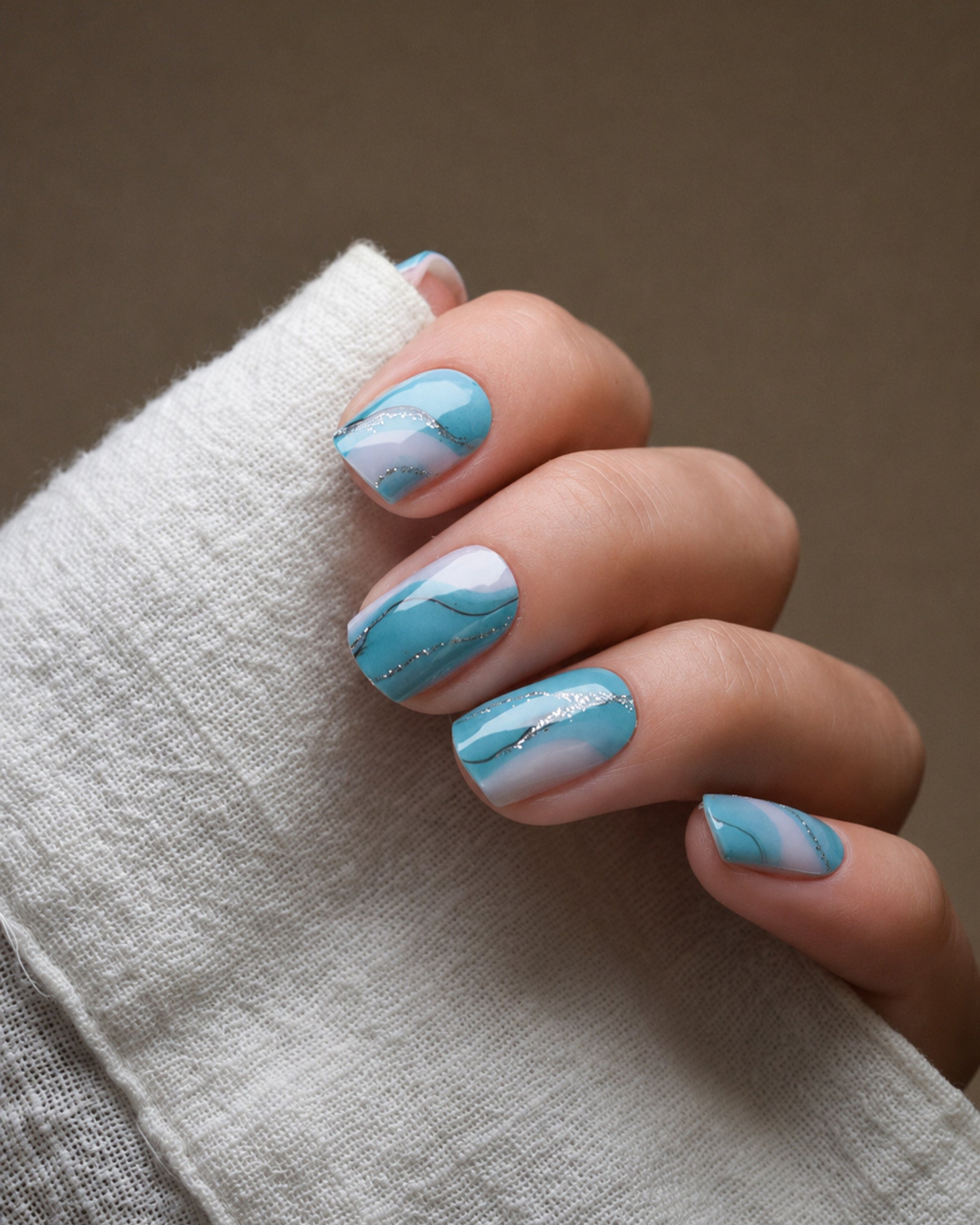 Tide & Seek UV Gel Wraps mit türkis-blauem Marmoreffekt inspiriert von Wellen und Meereswasser.
