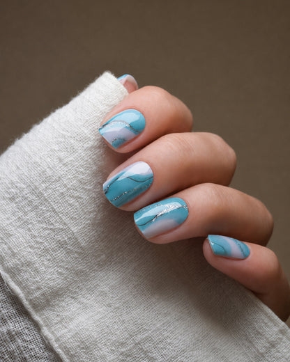 Tide & Seek UV Gel Wraps mit türkis-blauem Marmoreffekt inspiriert von Wellen und Meereswasser.